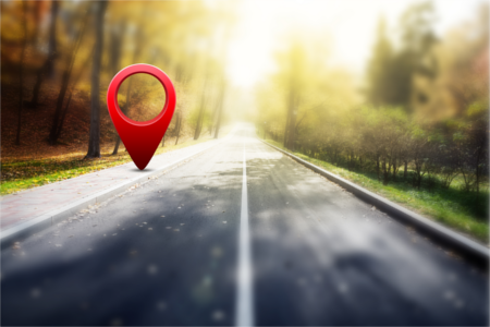 Roter GPS-Marker auf einer Herbststraße