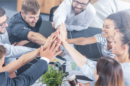 Ein Gruppe Geschäftsleute arbeiten erfolgreich im Team und zeigen das, durch ein high five nach der Besprechung.