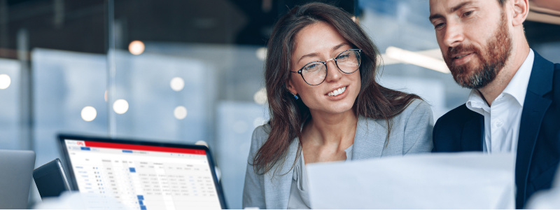 Zwei Mitarbeiter arbeiten am Computer mit Sales CPQ von Merlin um ihre Preisgestaltung zu analysieren.